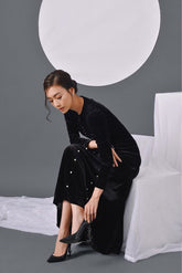 Elegant velvet long-sleeve evening dress with pearl embellishments and flowing silhouette